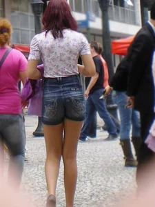 Redhead girl with her cheeks eating her denim shorts
