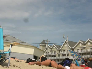 Milf laying out on a beach in Maine in her little thong