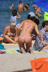 Sexy milf in pink thong bikini on the beach
