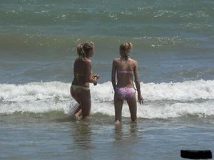 Sexy blonde on the beach in a yellow thong bikini