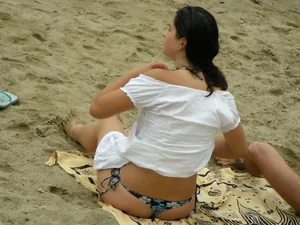 Sexy girl in a blue floral thong bikini at the beach