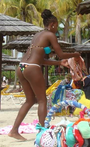 Sexy black babe in various bikinis on the beach while on vacation