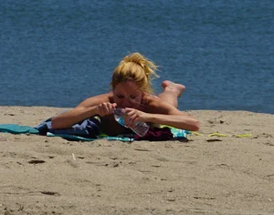Sexy ass blonde milf on the beach in a thong with cameltoe and bending over