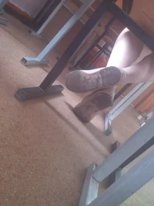 Crossed Legs of a College Student Under Desk