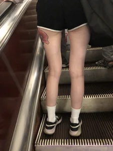 A Tall And Slim Candid Girl in Spandex Shorts in a Hoodie Top, With Tattoos on Her Long Legs Subway Creepshots