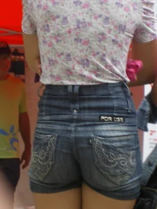 Redhead girl with her cheeks eating her denim shorts
