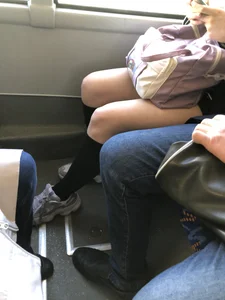 A Very Cute And Skinny Candid Teen Girl Wearing Glasses, A Skirt And Knee Socks Sitting in a Public Bus, Closeups of Her Legs