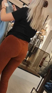 Blonde dutch shop assistent in orange cord leggings