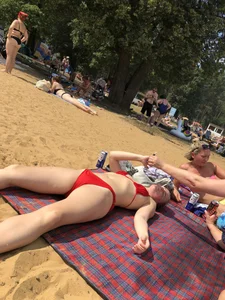 Girl in a Red Swimsuit Lying on a Beach With Spread Legs Photos