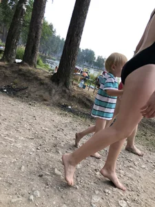 Cute Barefoot Girl in a Black Body Swimsuit Walking on a Road