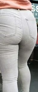 Blond girl in tight grey jeans waiting for the bus