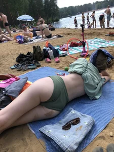 Cute Candid Girl in a Green Swimsuit With Pale Skin Lying on the Beach