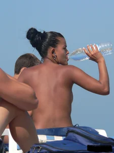 Hot ass topless beach girl with great tits lets her little brother oil up her ass in thong bikini
