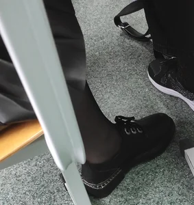 Teenage Girl's Foot in a Shoe And Black Pantyhose Under Desk in Class