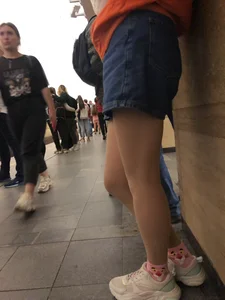 Subway Candid Girl in Denim Shorts and Sneakers Sitting With Crossed Legs in the Train