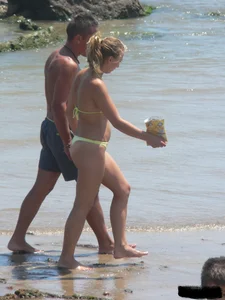 Sexy blonde on the beach in a yellow thong bikini