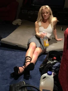 Hot Blonde Girl in High-Heeled Shoes and a Skirt Sitting on the Floor at the Party Creepshots