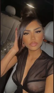 Car Selfie of a Girl With Heavy Makeup in a See Through Black Blouse, Her Breast And Nipples Showing