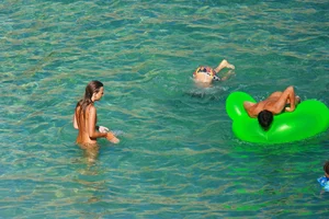 FKK Nudists playing in the water with floater