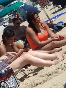 Beach girl with big boobs in an orange swimsuit