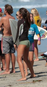 Hot Asian teen surfer at the beach in little shorts showing her bikini vpl underneath