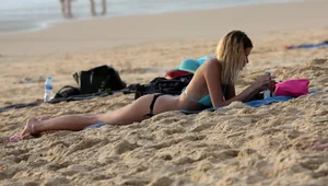 Sexy blonde laying out in black thong bikini