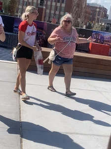 Bunch of girls in various outfits at a Cardinals baseball game