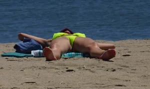 Sexy ass blonde milf on the beach in a thong with cameltoe and bending over