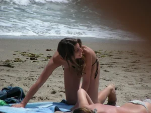 Topless girl with tan lined tits and in a black thong bikini