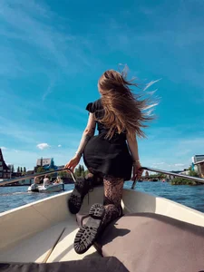 Girl in Black Pantyhose and a Dress on the Boat with Wind in Her Hair