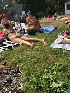 Amazing chick in a swimsuit laying on grass in a park