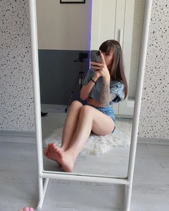 Cute Slim Girl With Bare Feet Sitting on The Floor in Mini Shorts Mirror Selfie