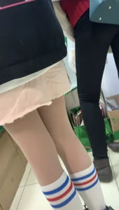 College teen's slim legs closeup in knee socks and pantyhose - wearing a backpack and a skirt