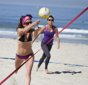 Hot girls playing beach volleyball in bikinis and shorts