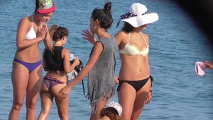 A sexy skinny girl on the beach in a bikini with sexy friends in bikinis