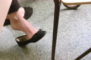 Feet in Flats under Desk Candid Closeup in College Classroom