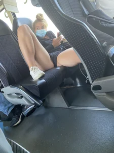 Blonde teen in a mask and mini shorts spreading her legs while sitting on the bus seat
