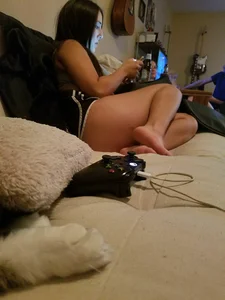 Barefoot girl in shorts sitting in bed