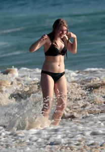Cute bikini girl in the water in a black bikini