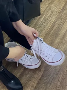 College Candid Teen in Pantyhose And a Skirt Putting On Her Sneakers in Classroom
