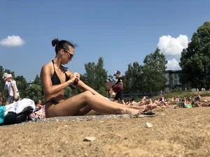 Gorgeous milf rubbing sun lotion in her skin at the beach, with a couple of her milf friends