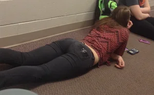 College teen in tight jeans laying on the floor