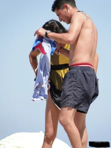 Topless lady on the beach in a gold thong with a nice ass