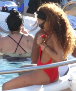 Sexy black girl in red swimsuit at the pool with side boob and a nice ass