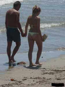 Sexy blonde on the beach in a yellow thong bikini