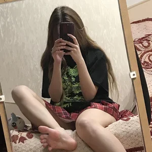Skinny Barefoot Girl Sitting in Bed in a Skirt Mirror Selfie