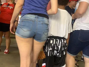 Bunch of girls in various outfits at a Cardinals baseball game