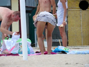 Topless blonde babe on the beach with a big booty in a black thong