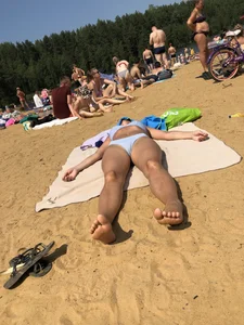 Girl With Covered Face Lying on a Beach on Her Back