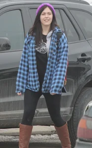 A cute brunette in leggings boots and hat